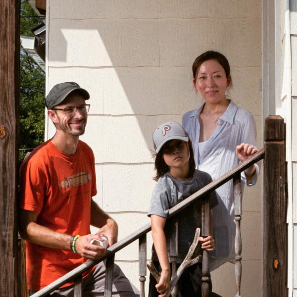 A mother and father smile on a staircase with their young son between them