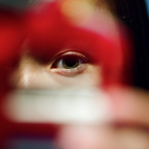 Young person peering through a cookie cutter into the camera lens