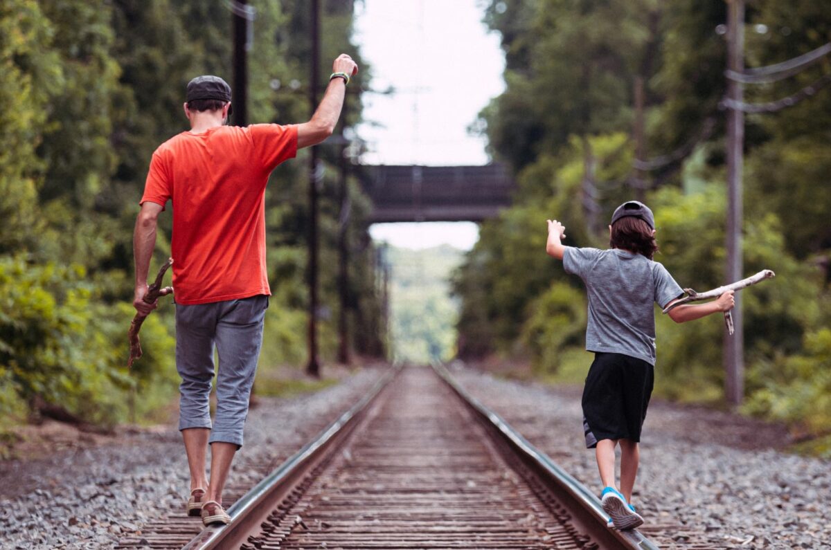 Kai and Dan balancing on train tracks amongst a forest