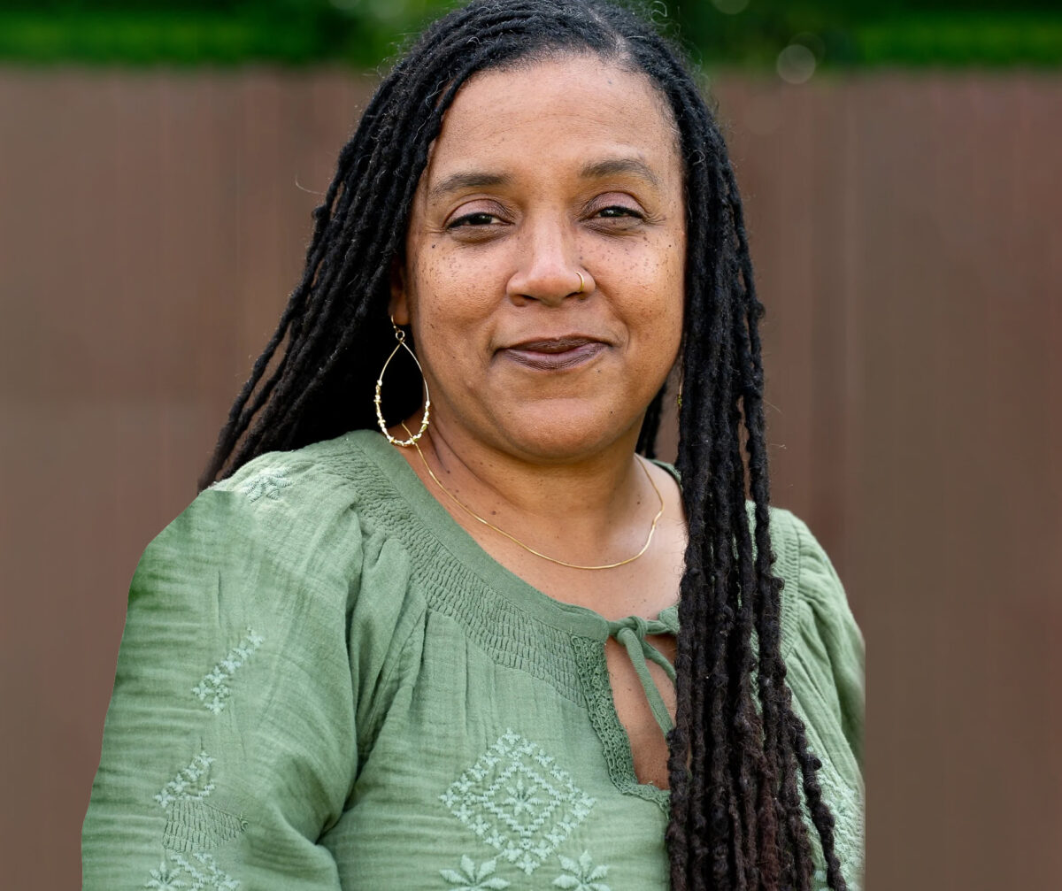A headshot of Leslie Bray in a smocked green top with hoop earrings.