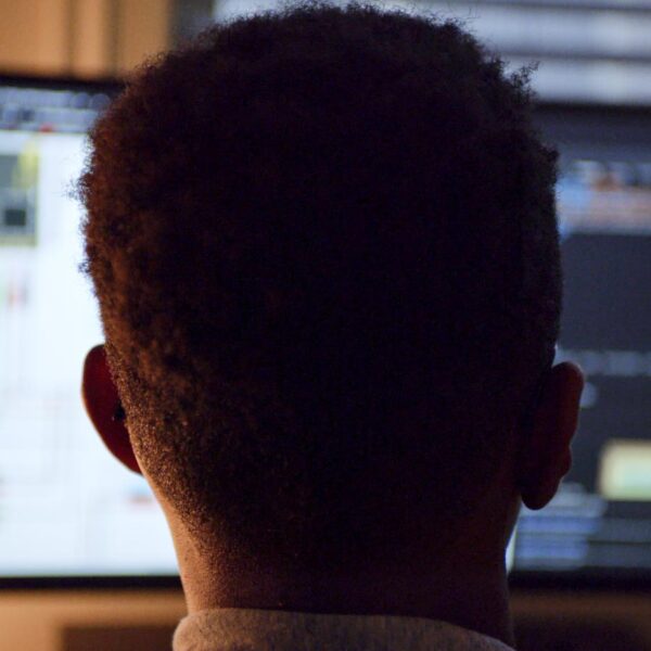 A boy looking at a large computer screen