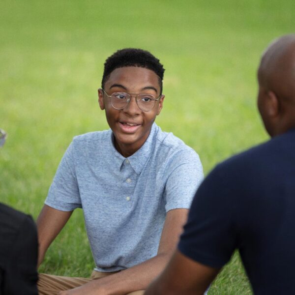 A teenage boy talks to his mom and dad